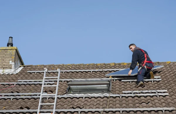 男人放在屋顶上的太阳能电池板 — 图库照片