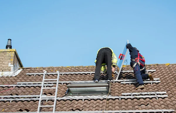 Uomo mettendo il pannello solare sul tetto — Foto Stock