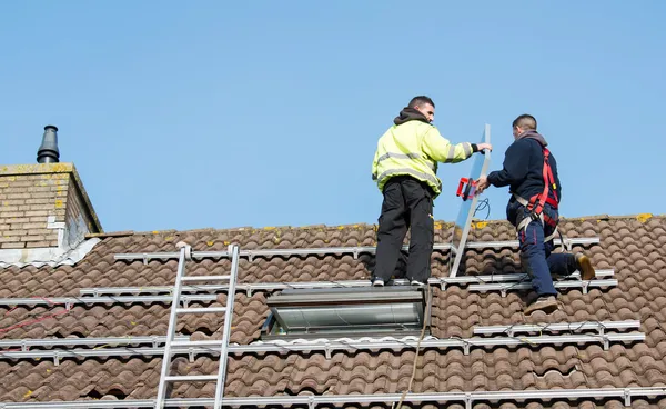 Mannen att sätta solpaneler på taket — Stockfoto