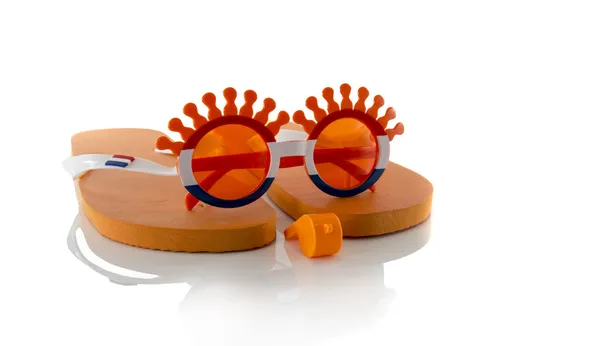 Plast glasögon horn flöjt tofflor och flaggan i orange — Stockfoto