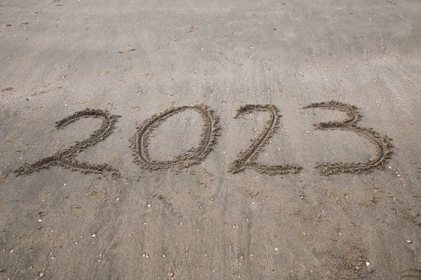 The text 2023 written in the sand on the beach — Zdjęcie stockowe