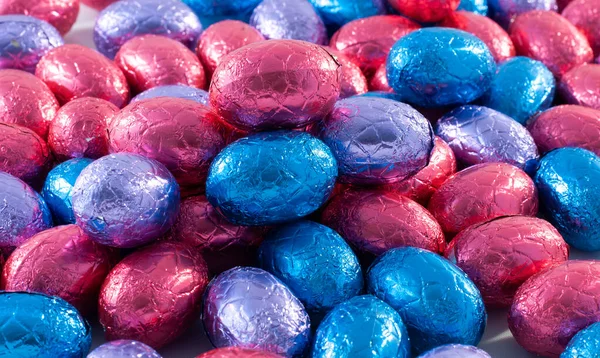 Schokoladeneier in rotem und blauem Hintergrund — Stockfoto