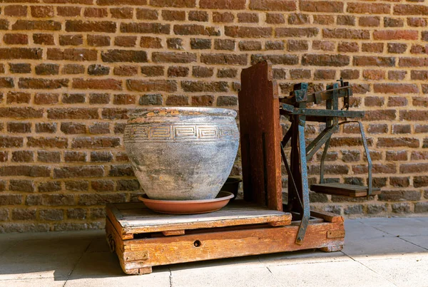 Old stone vase on a wooden scale — Stock Photo, Image