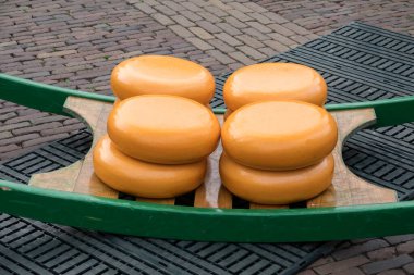 4 large cheeses of 25 kg each are ready on a carrier for transport at the cheese market in Alkmaa, a traditional cheese market in the Netherlands for 400 years