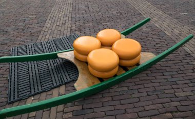 4 large cheeses of 25 kg each are ready on a carrier for transport at the cheese market in Alkmaa, a traditional cheese market in the Netherlands for 400 years