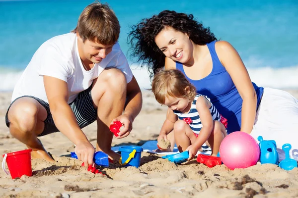 Familia jugando en la playa — Foto de Stock