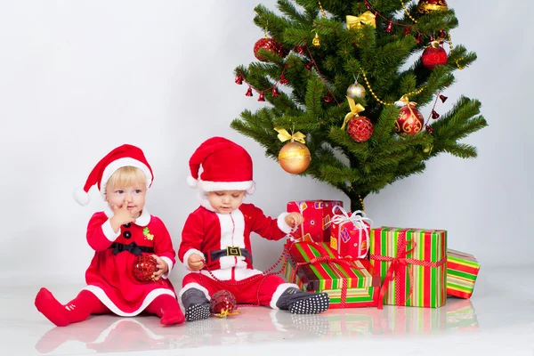 Duas crianças sob pinho de Natal — Fotografia de Stock