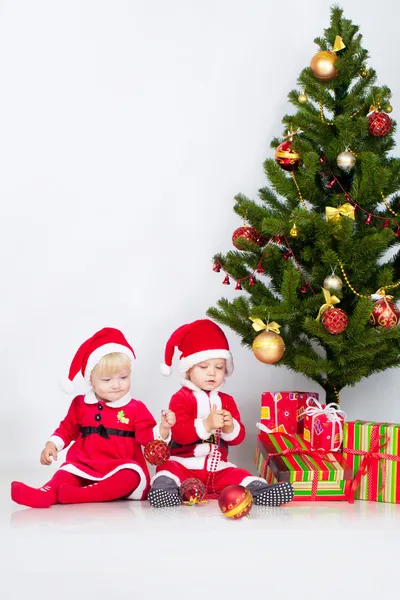 Två barn under julen tall — Stockfoto