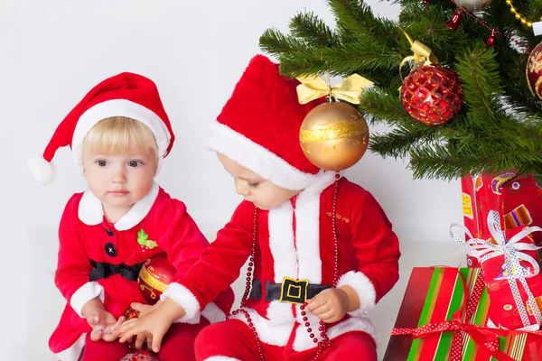 Duas crianças sob pinho de Natal — Fotografia de Stock
