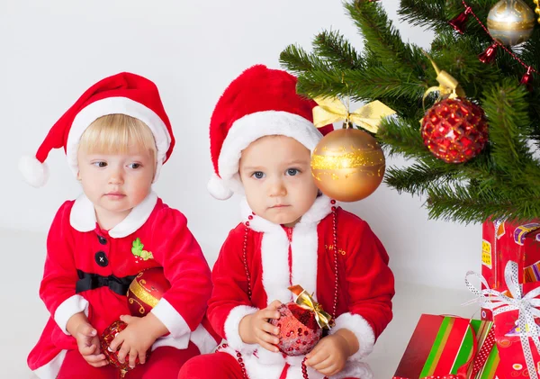 Two children under christmas pine — Stock Photo, Image