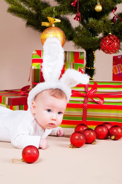 Baby under christmas pine — Stock Photo, Image