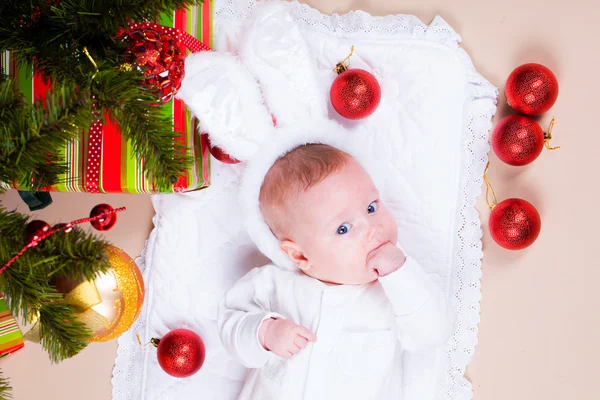 Baby under christmas pine — Stock Photo, Image