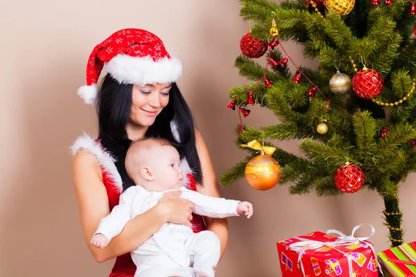 Frau mit Baby in der Nähe von Weihnachtskiefer — Stockfoto