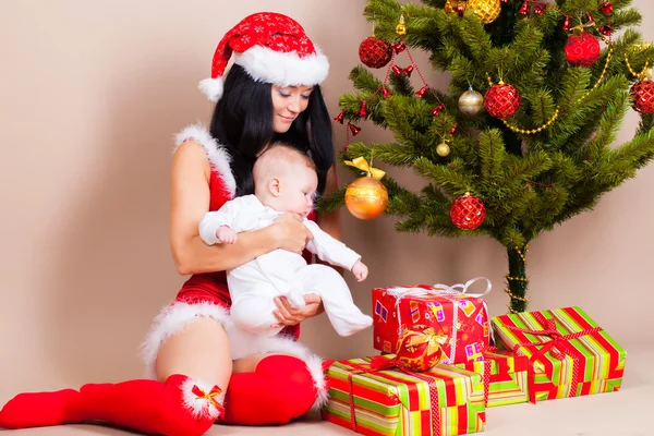 Frau mit Baby in der Nähe von Weihnachtskiefer — Stockfoto