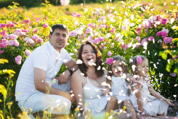 Familia en jardín de rosas — Foto de Stock