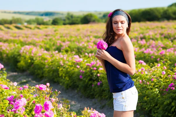 Žena v růžové zahradě — Stock fotografie