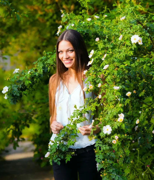 Vrouw in de buurt van rose bloem — Stockfoto