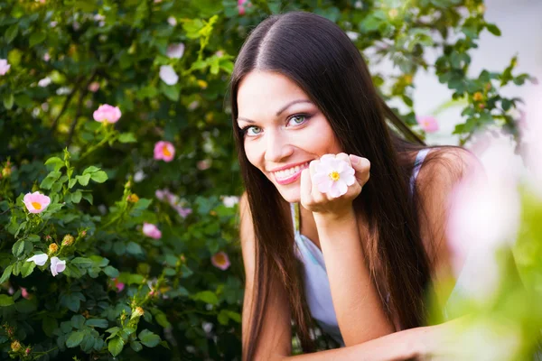 Vrouw in de buurt van rose bloem — Stockfoto