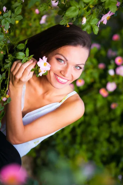 Mulher perto rosa flor — Fotografia de Stock