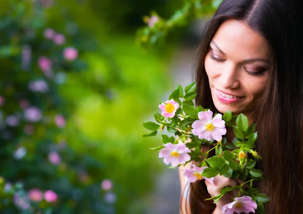 Kvinna nära rosa blomma — Stockfoto