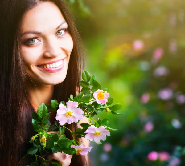Kvinna nära rosa blomma — Stockfoto