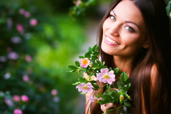 Kvinna nära rosa blomma — Stockfoto