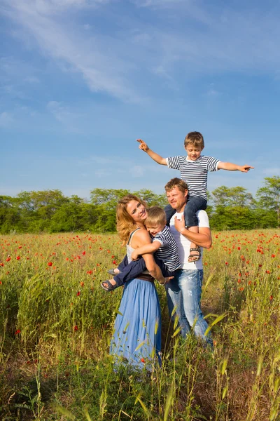 Family on the poppy meadow Stock Photo