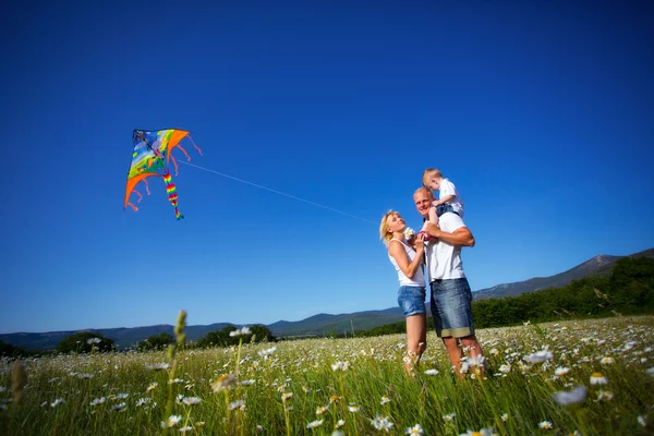 Family playing with kite — Stockfoto