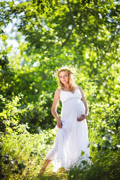 Zwangere vrouw in groen bos — Stockfoto