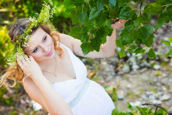 Těhotná žena v zeleném lese — Stock fotografie