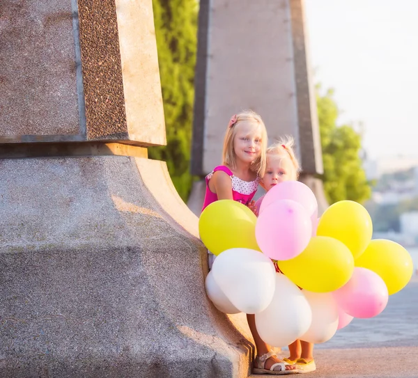 Twee kleine meisjes met ballonnen — Stockfoto