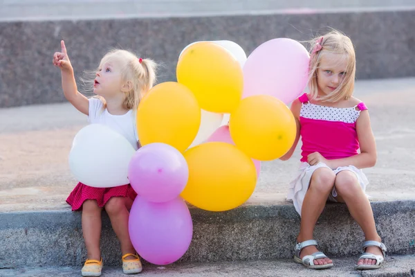 Two little girls with balloons — Stock Photo, Image