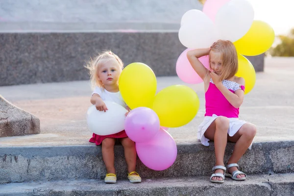 Two little girls with balloons — Stock Photo, Image