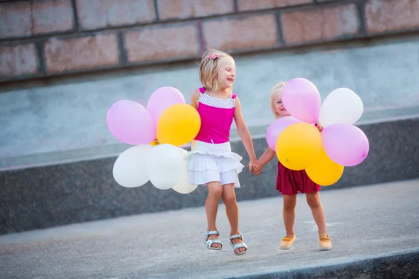 Two little girls with balloons — Stock Photo, Image