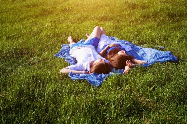 Genç çift çimlerin üzerinde yatıyor.