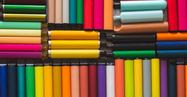 Bir sürü elektronik sigara ve vipes ahşap arka planda yayılmış. Alternatif sigara. Kötü alışkanlıklar.