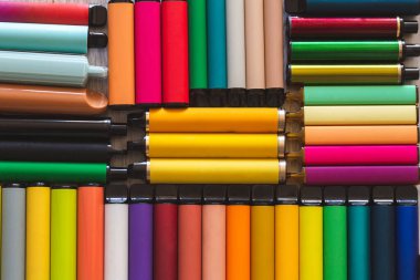 Bir sürü elektronik sigara ve vipes ahşap arka planda yayılmış. Alternatif sigara. Kötü alışkanlıklar.