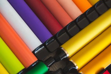 Bir sürü elektronik sigara ve vipes ahşap arka planda yayılmış. Alternatif sigara. Kötü alışkanlıklar.