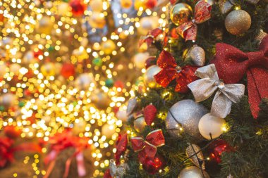 Altın ve kırmızı renkli toplarla süslenmiş bir sokak Noel ağacı parçası. Bulanık arkaplan