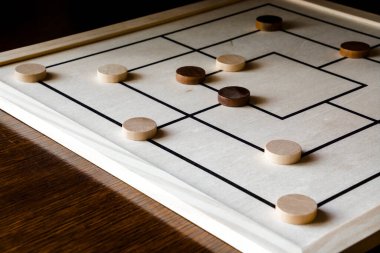 Nine-man morris board game on a wooden table