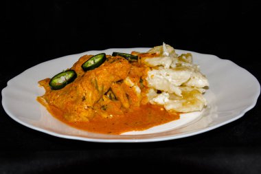 Beyaz tabakta erişteli yayın balığı güveci.