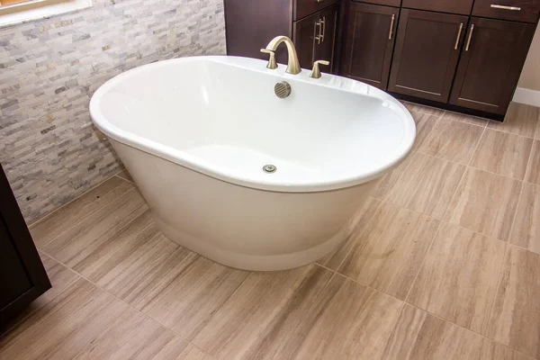 Master Bathroom With Free Standing Oval Tub And Cabinets