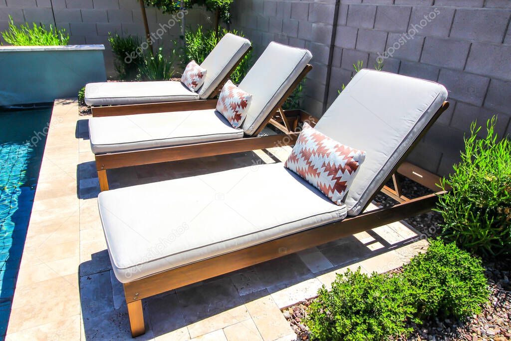 Three Adjustable Lounge Chairs By Swimming Pool
