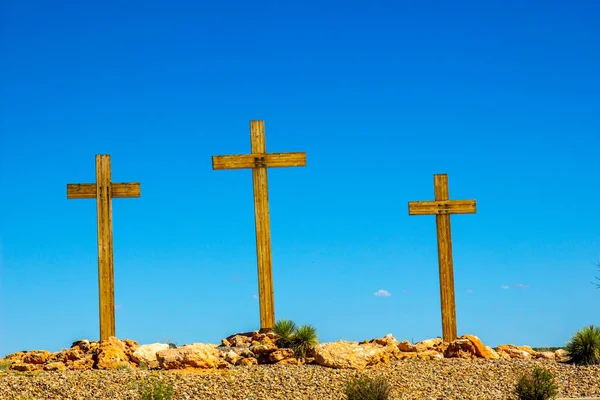 Three Wooden Crosses On Desert Hilltop
