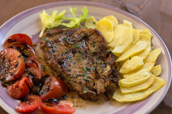 Schweinesteak mit Kartoffeln und Tomaten — Stockfoto