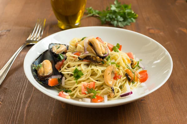 Spaghetti with mussels, tomato, onion and parsley — Stock Photo, Image