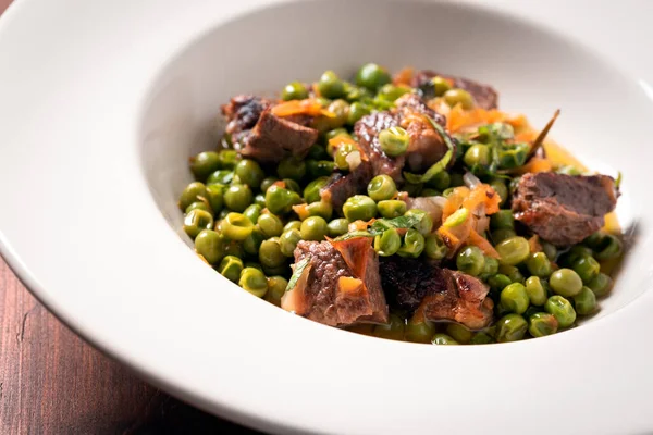 ニンジンやエンドウ豆とおいしいポークシチューの料理 イタリア料理 ロイヤリティフリーのストック画像
