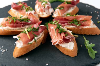 Peynirli, roket salatalı ve İtalyan aperatifli lezzetli crostini tabağı.