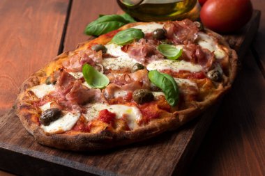 Prosciutto, mozzarella, domates sosu, zeytin ve kekik soslu nefis Roma pinsası. 