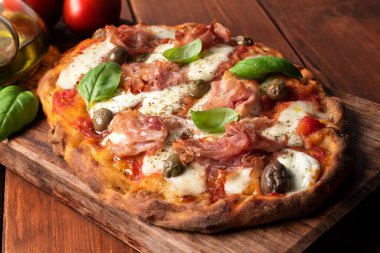 Prosciutto, mozzarella, domates sosu, zeytin ve kekik soslu nefis Roma pinsası. 